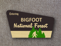 image of big foot walking in from of national forest sign with text entering bigfoot national forest